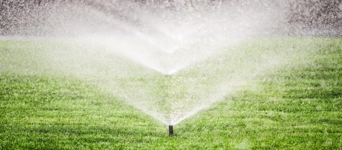 Several garden sprinklers on the grass field